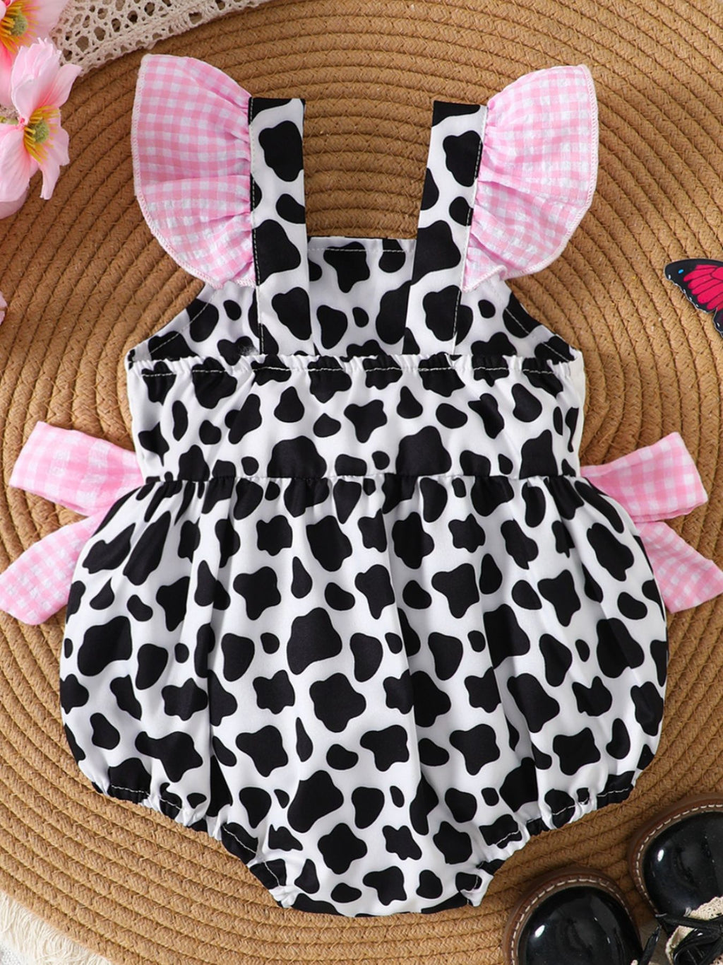 “Cow print baby romper detail shot”